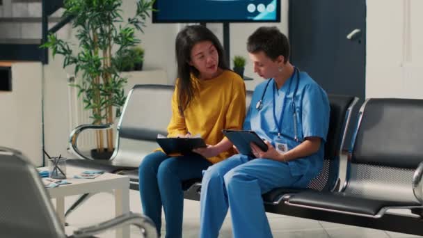 Różnorodna Pielęgniarka Pacjent Patrząc Dokumentację Medyczną Przed Rozpoczęciem Wizyty Kontrolnej — Wideo stockowe