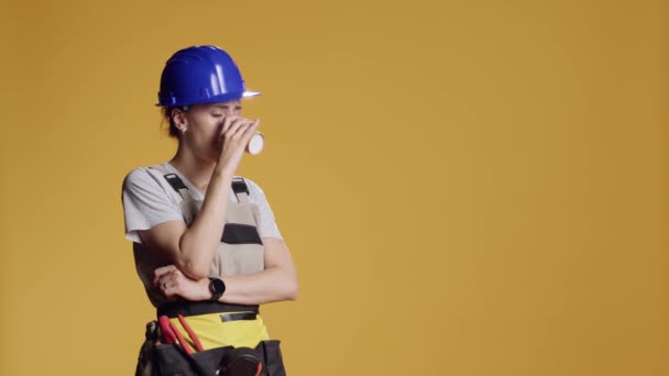睡意朦胧的女仆在建筑施工时喝着咖啡杯的画像 感到精疲力竭 睡着了 建筑工人在黄色背景下提供浓缩咖啡和饮料 — 图库视频影像