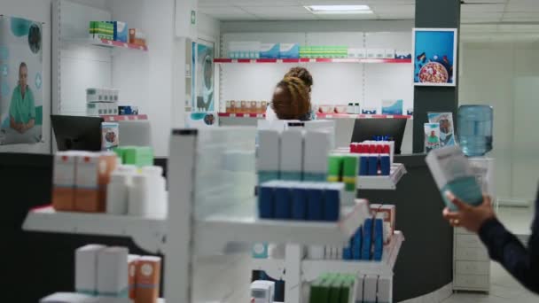Kvinnliga Farmaceuter Som Förklarar Sjukvårdsprodukter För Asiatiska Klienter Vid Apoteksdisken — Stockvideo