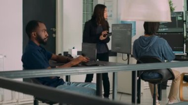 html betiği ve sunucu kodu ile geçici pencere üzerinde çalışan yazılım geliştiricisi, veri odasında oturuyor. Sistem mühendisi kullanıcı arayüzü geliştirme ajansında çalışıyor. Üçayak atışı.