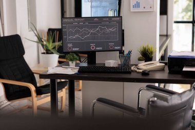 İçinde kimse olmayan veri analiz şirketi, dost ofisi devre dışı bıraktı. Gündüz modern tasarım ile boş başlangıç işi bilgisayar monitöründe yıllık grafikler çalışıyor.