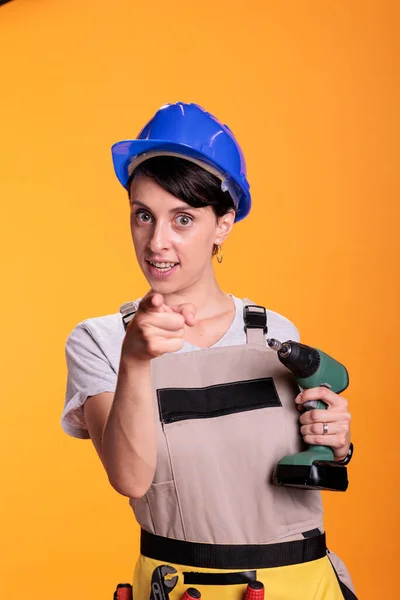 Mujer Trabajadora Construcción Apuntando Con Dedo Índice Cámara Sosteniendo Pistola —  Fotos de Stock