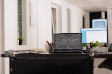 Portatif bilgisayarı, cihazı ve masadaki bazı kağıtları olan bir çalışma istasyonu. İnsansız iş yerinde yıllık istatistiksel raporla göster.