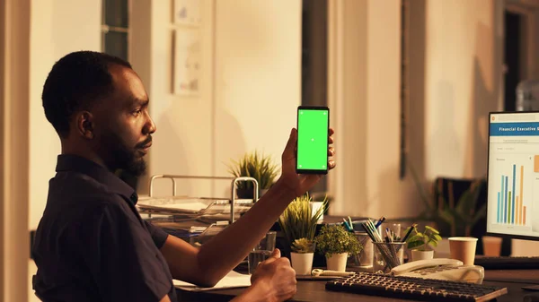 Şirket Çalışanı Cep Telefonuyla Yeşil Ekran Görüntüsüne Bakıyor Bilgisayarla Ticaret — Stok fotoğraf