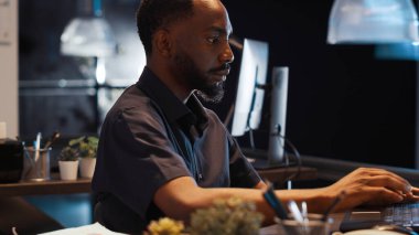 Afrika kökenli Amerikalı bir adam gece geç saatlerde ev telefonuna cevap veriyor. Küçük işletme bürosunda iş raporları üzerinde çalışıyor. Online verilerle kurumsal proje ve e-ticaret sunumu planlanıyor.