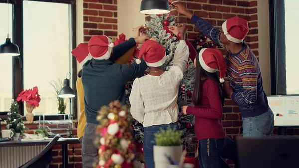 Multietnická Skupina Spolupracovníků Zdobí Vánoční Stromeček Dává Slavnostní Ozdoby Startovací — Stock fotografie