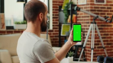 Ofis çalışanı yeşil ekran şablonu ile akıllı telefonu analiz ediyor, kroma anahtarı ve kopyalama alanı ile izole ekran kullanıyor. Kablosuz cep telefonunun boş model geçmişiyle çalışmak.