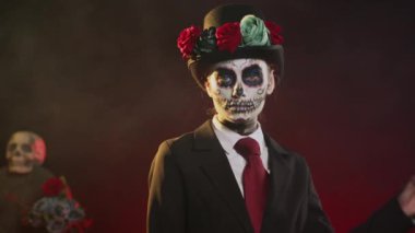 Cadılar Bayramı kostümlü ürkütücü tanrıça. Kafatası ile Meksika geleneğini kutluyorlar. Stüdyoda poz veriyorlar. Santa Muerte törenindeki ölüm bayanı gibi görünüyorsun. El kamerasıyla..