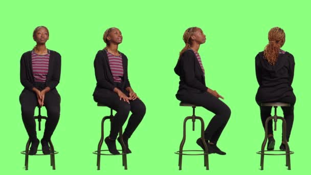 フルボディの緑の背景に4つの側面の椅子に座っているカジュアルな人は 行を待って準備します リラックスした女性は緑の画面の背景の上に準備に座っている — ストック動画