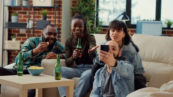 사람들 스마트폰으로 재미있는 비디오를 병에서 맥주를 마시고 집에서 모임을 즐기고 — 스톡 사진
