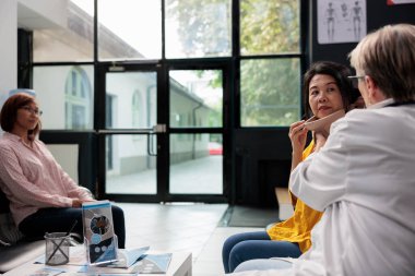 Boyunluğu olan yaşlı bir hastaya, kaza sonrası rehabilitasyondan sonra boyunluğunu çıkarması için yardım eden bir tıp uzmanı. Yaralı kadın, iyileşen kırık, travma ve sağlık kontrolü yapıyor. Tıp konsepti