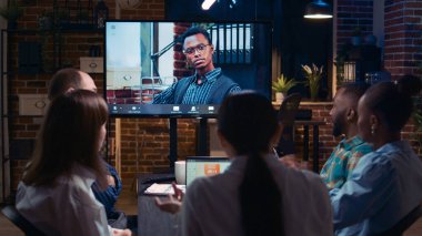 Proje yöneticisiyle video konferansında şirket gelirleri sunumu tartışması, video konferansında konuşan çeşitli insanlar. Ofis çalışanları uzaktan kumandalı ekiple telekonferansta sohbet ediyor.