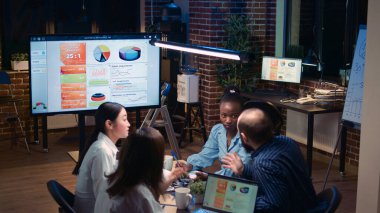 Çeşitli iş adamlarının analitik raporları toplantıda sunum yapması, iş arkadaşlarıyla iletişim kurması, toplantı masasında iş arkadaşlarının konuşması. Çalışanlar satış stratejisi planlıyor