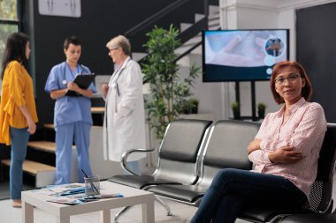 Tıbbi konsültasyona katılmak için lobide bekleyen hasta portresi, reçeteli ilaç ve tedavi görmek için check-up ziyareti. Hastanedeki yaşlı Asyalı kadın..