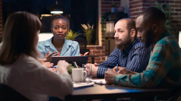 戦略計画ビジネスミーティング アフリカ系アメリカ人従業員の発言 多様な同僚のブレインストーミング 戦略の議論 オフィスワーカーがコワーキングスペースのテーブルで話しています 三脚ショット — ストック写真