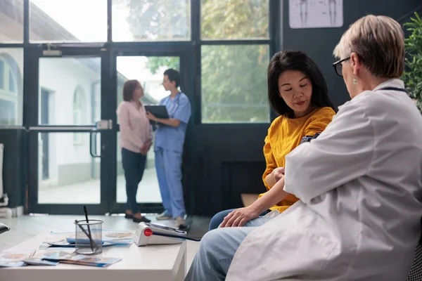 Alter Arzt Bei Der Hypertonieuntersuchung Mit Tonometer Wartezimmer Des Krankenhauses — Stockfoto