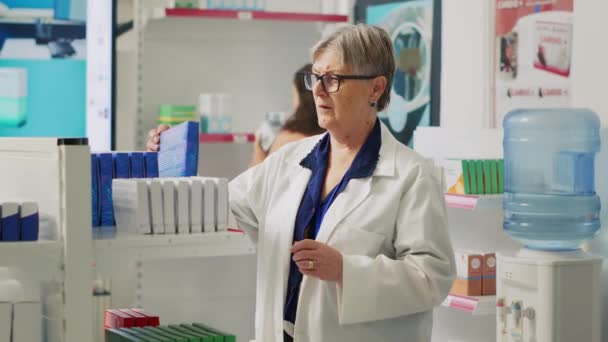 Ahli Farmasi Lansia Melihat Kotak Medicaments Rak Apotek Memeriksa Selebaran — Stok Video