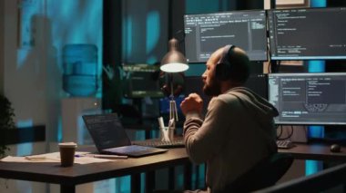 Aptal web geliştiricisi davul çalıyor ve kulaklıkla müzik dinliyor, şarkıdan keyif alıyor ve yeni kullanıcı arayüzü programlama üzerinde çalışıyor. Erkek programcı eğleniyor, eğleniyor ve dikkatsiz davranıyor..