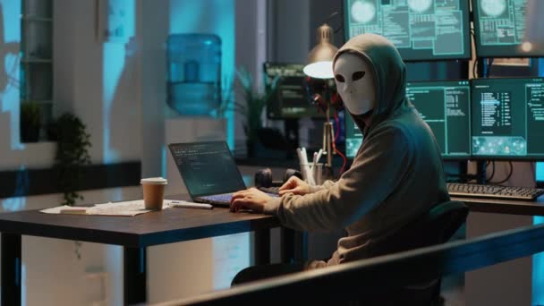 带匿名面具的网络冒名顶替者破坏安全系统 安装病毒以制造计算机恶意软件并窃取在线数据 蒙面犯罪分子深夜黑客攻击网络服务器 — 图库视频影像