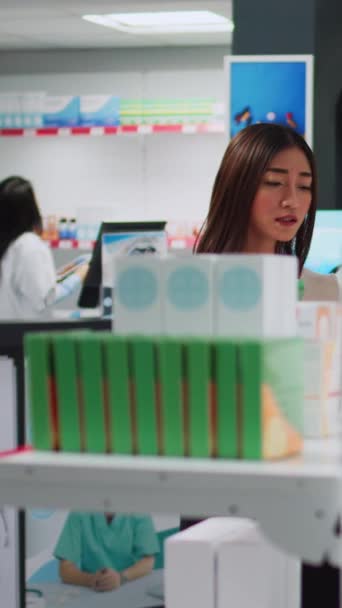 Vídeo Vertical Joven Examinando Cajas Medicamentos Estantes Farmacia Buscando Medicamentos — Vídeos de Stock