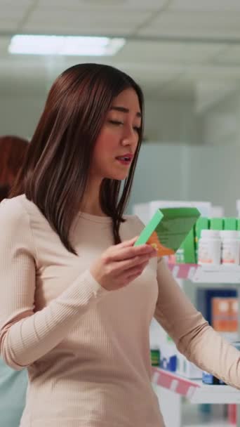 Вертикальне Відео Жіночий Клієнт Читає Листівки Фармацевтичних Препаратів Аптеці Перевіряє — стокове відео
