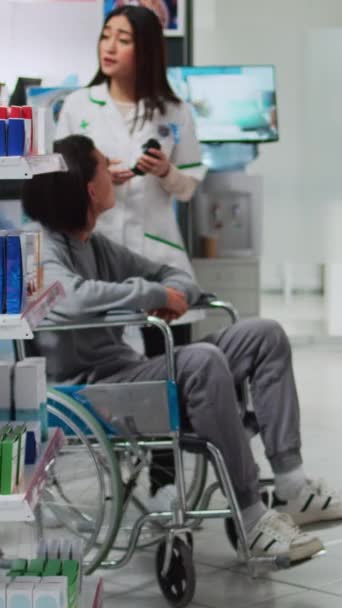 Vídeo Vertical Jovem Usuário Cadeira Rodas Conversando Com Farmacêutico Sobre — Vídeo de Stock