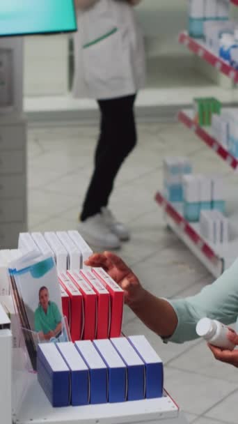 垂直视频 有心脏问题的妇女检查心脏科药丸盒 寻找药物治疗 在药店货架上有疾病分析药品的亚洲人 — 图库视频影像