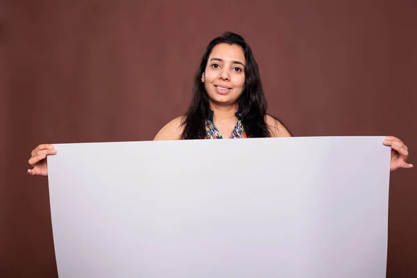 微笑的印度女人拿着空白的横幅和复制空间进行促销 看着相机 模特儿站在那里 手里拿着空白的白板 做广告模特儿 — 图库照片