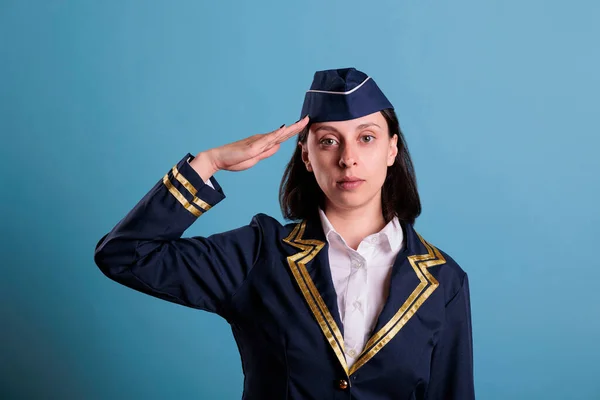 Young Serious Stewardess Saluting Wearing Flight Uniform Standing Looking Camera — Stock Photo, Image