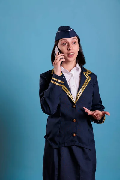 Uśmiechnięta Stewardessa Dzwoniąca Zdalnie Przez Telefon Komórkowy Stewardessa Mundurze Lotniczym — Zdjęcie stockowe