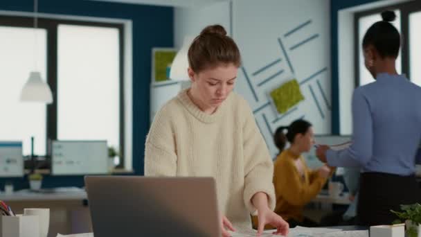 重点突出的初创员工在笔记本电脑上的形象和对比销售数据的图表 办公室里忙着整理分析数据分析的商业文件的妇女 — 图库视频影像