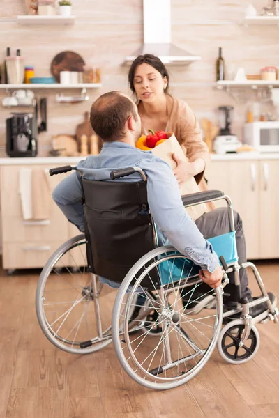Żona Biorąc Torbę Spożywczą Niepełnosprawnego Męża Wózku Inwalidzkim Przybyciu Supermarketu — Zdjęcie stockowe