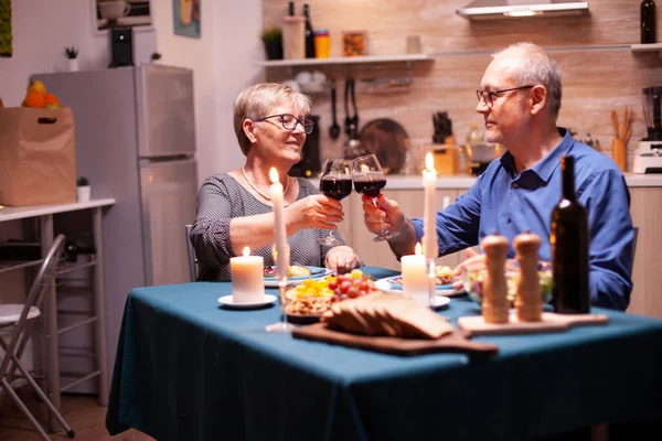 Kerzen Brennen Auf Dem Küchentisch Und Ein Altes Paar Stößt — Stockfoto