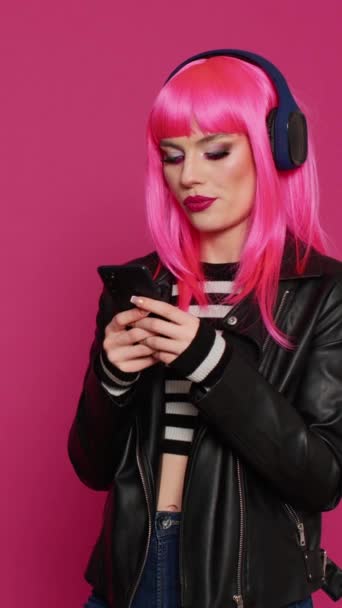 분홍색 글자를 문자로 보내는 쾌활하고 자신있는 헤드폰으로 음악을 스마트폰에서 미디어 — 비디오