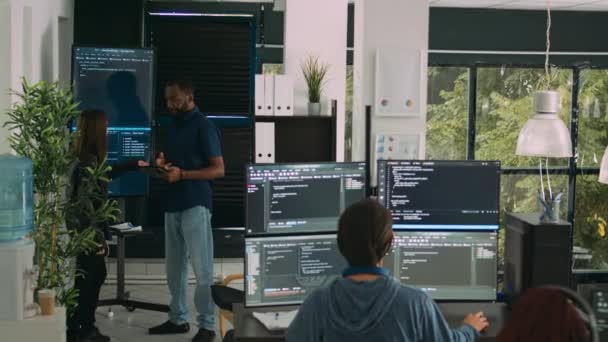 多样化的软件工程师团队在壁屏电视上分析代码 使用数字平板电脑 并与艺术智慧一起工作 用海量数据解析云计算项目的编码器 — 图库视频影像