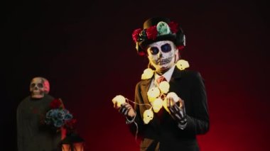 Stüdyoda müzik dinleyen, Cadılar Bayramı kostümü giyen ve dans eden ürkütücü bir kadın. Ölüm gününü kutlamak için dans hareketleriyle La Cavalera Catrina gibi tuhaf davranıyor. El kamerasıyla..