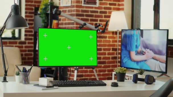 モニター上の緑の画面テンプレートと空のオフィスデスク コンピュータ上で実行されている隔離されたモックアップの背景 クロマキーディスプレイ上の空白のコピースペースを持つデスクトップPc 緑の画面をモック — ストック動画