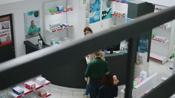 多族裔群体的客户从药店货架上取药 用信用卡支付药丸 用Nfc智能卡和电话 在药店买药品的人 — 图库视频影像