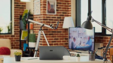 Uzaktan çalışmak için dizüstü bilgisayarı olan boş bir çalışma masası, yeni bir iş öğrenmek için dairede bilgisayar kullanan yaratıcı bir çalışan. Oturma odasındaki bilgisayar muhasebe ve pazarlama işine alışkındır..