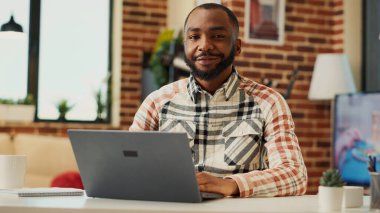 Evden uzakta çalışan, bilgisayarını kullanan ve satış ağında iş raporu yazan Afrikalı bir Amerikalı. Erkek serbest çalışan dairede öğreniyor, muhasebe eğitimi alıyor. El kamerasıyla..
