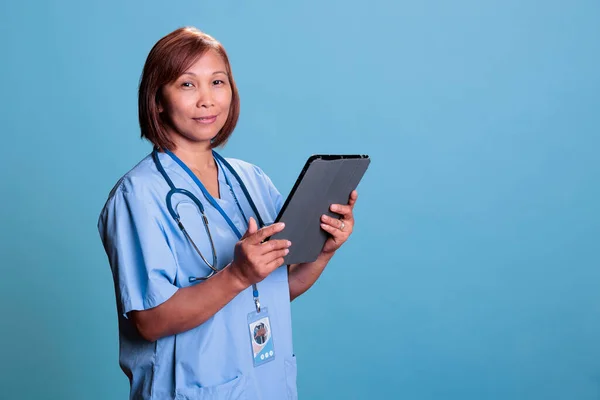 Азиатская Медсестра Держит Планшетный Компьютер Проверяя Медицинские Рецепты Перед Началом — стоковое фото