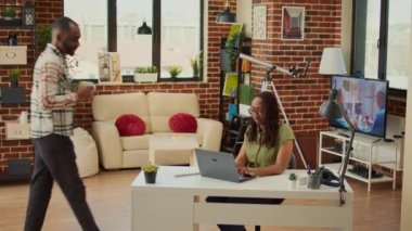 Evde dizüstü bilgisayarla çalışan bir şirket çalışanı. Oturma odasında erkek arkadaşıyla veri raporu hazırlıyor. Ofis çalışanı masada oturuyor ve muhasebe işlerini yapıyor, profesyonel e-posta gönderiyor..