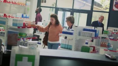 Genç yetişkin bilincini kaybediyor ve eczane raflarının yanında neredeyse bayılıyordu. Eczacı, başı dönen müşteriye yardım ediyor. Uzman, dönen duyusu olan birine destek veriyor. Hollanda açısı.