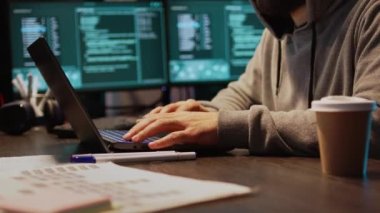 Genç hackerın bilgisayardaki veritabanı sunucusuna girmesi sistemden büyük veriler çalmak için kötü amaçlı yazılım kullanması. Önemli bilgileri hacklemek için gece boyunca birden fazla monitörle çalışmak. El kamerasıyla..