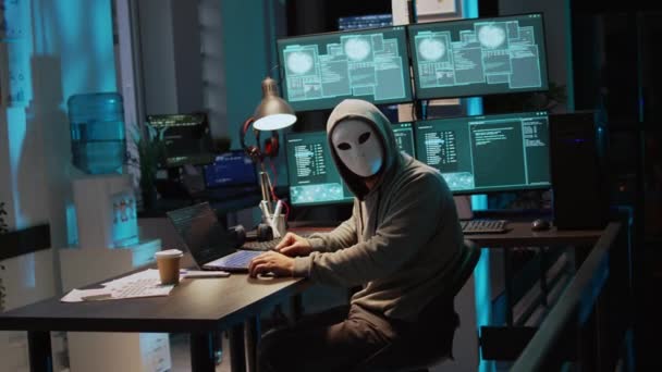 男性罪犯戴着面具和头罩侵入计算机系统 闯入公司服务器窃取大数据 戴面具的人看起来很危险 很可怕 是个冒牌货 制造安全软件 手持射击 — 图库视频影像