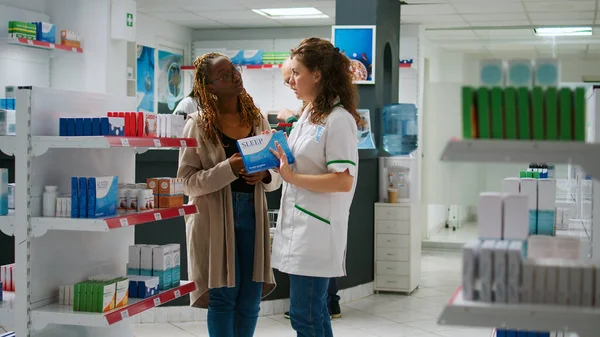 Kadın Eczacı Afrika Kökenli Amerikalı Müşterilerin Ilaç Seçmesine Yardım Ederek — Stok fotoğraf