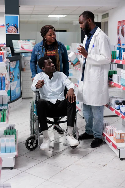 Farmacista Afroamericano Che Aiuta Uomo Sulla Sedia Rotelle Scegliere Farmaci — Foto Stock