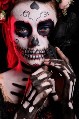 Stüdyoda elinde siyah güller tutan göz kamaştırıcı ölüm kadını makyaj yapmış La Cavalera Catrina Kafatası 'na benziyor. Dios de los muertos 'ta geleneksel cadılar bayramı kostümüyle Santa Muerte tanrıçası..