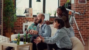Mutlu arkadaşlar video oyunlarını kutluyor konsolda kazanıyor, online mücadele oynuyor ve toplamada kazanıyor. İnsanlar neşeli ve neşeli hissediyorlar, evde eğleniyorlar. El kamerasıyla..