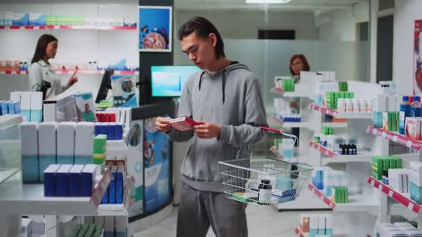 Asiatisk Klient Tittar Kardiologi Piller För Att Köpa Från Apotek — Stockvideo